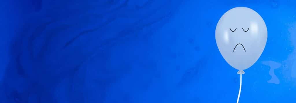 Picture of a sad balloon against a blue background