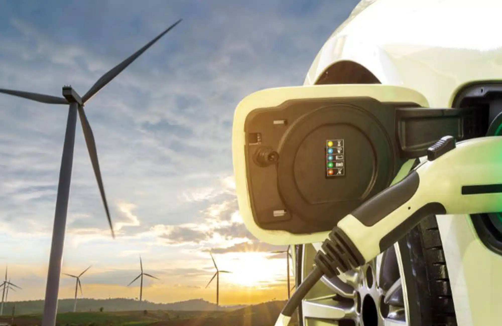 Sustainability recruitment image of electric car charging with wind turbines in distance