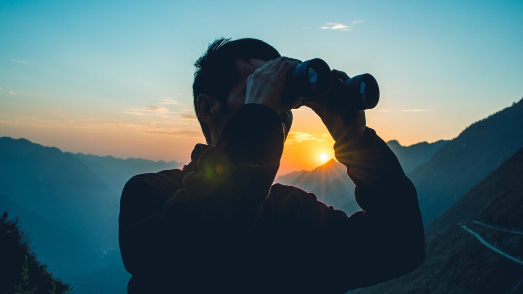 man looking in binoculars