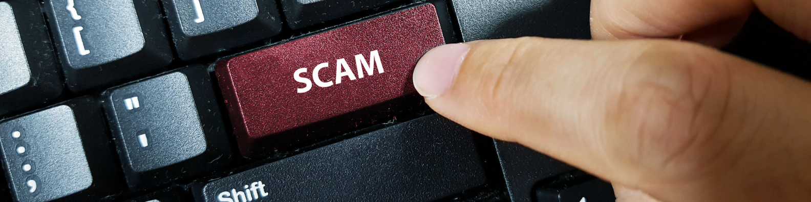 A finger pressing the scam button